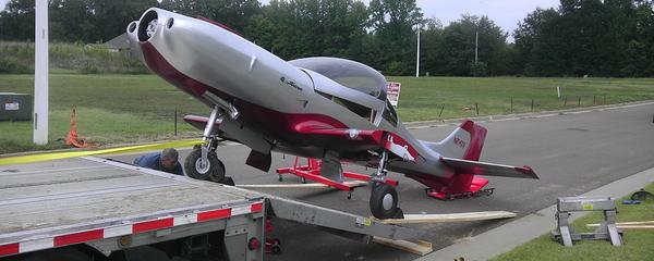 Small airplane transported on a highway trailer